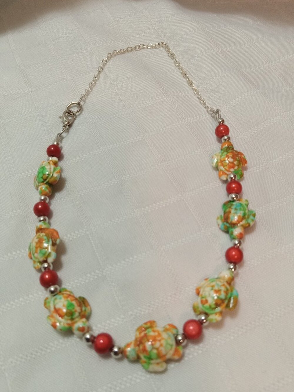 Pretty handmade necklace with little turtles and glass bead
